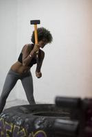 entrenamiento de mujer negra con martillo y neumático de tractor