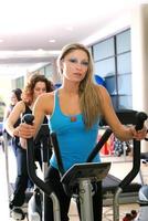 Women working out on spinning bikes at the gym photo