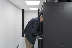 Technicians team updating hardware inspecting system performance in super computer server room or cryptocurrency mining farm. photo