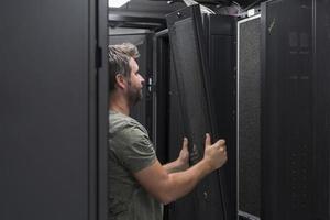 IT engineer working In the server room or data center The technician puts in a rack a new server of corporate business mainframe supercomputer or cryptocurrency mining farm. photo