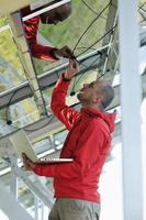 engineer using laptop at solar panels plant field photo