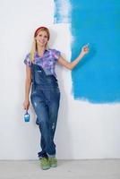 happy smiling woman painting interior of house photo