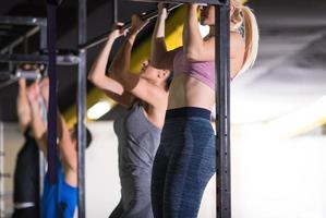 young athletes doing pull ups on the horizontal bar photo