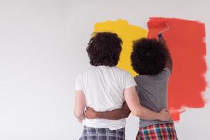 multiethnic couple painting interior wall photo