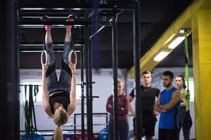 mujer trabajando con entrenador personal en anillos de gimnasia foto