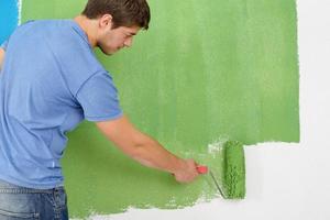 handsome young man paint white wall in color photo