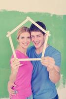 pareja feliz pintando una pared en su nuevo hogar foto