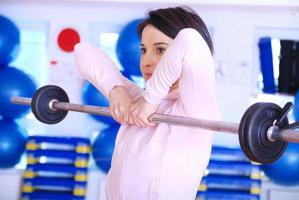 .a young woman weightlifting at gym photo