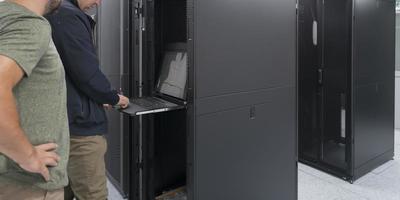 Technicians team updating hardware inspecting system performance in super computer server room or cryptocurrency mining farm. photo