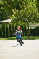 niño feliz aprendiendo a andar en bicicleta foto