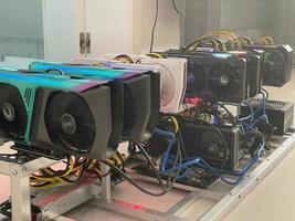 Row of bitcoin miners set up on the wired shelfs. Device for mining crypto currency. Mining cryptocurrency. Bitcoin farm. Machines for mining cryptocurrency bitcoin. Electronic device at day. photo