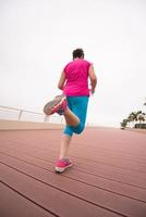 woman busy running on the promenade photo