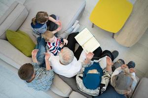 top view of modern muslim grandparents with grandchildren reading Quran photo