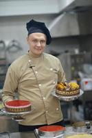 chef preparando pastel de desierto en la cocina foto