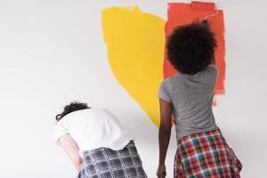 multiethnic couple painting interior wall photo