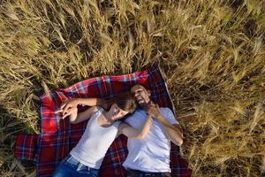 pareja feliz en campo de trigo foto