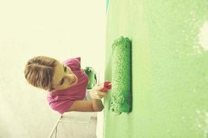 mujer sonriente feliz pintando el interior de la casa foto