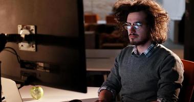 man working on computer in dark office photo