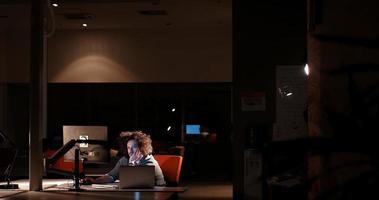 hombre trabajando en una computadora en una oficina oscura foto