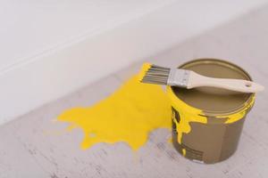 Yellow paint tin can with brush on top photo