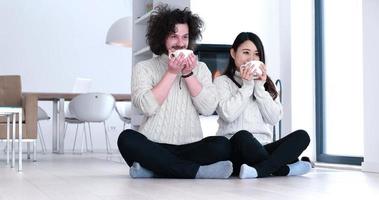 multiethnic romantic couple  in front of fireplace photo