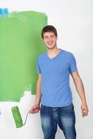 handsome young man paint white wall in color photo