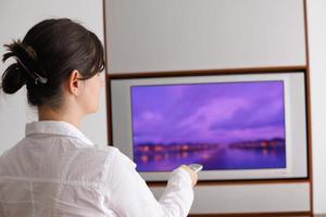 mujer joven viendo tv en casa foto
