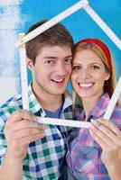 pareja feliz pintando una pared en su nuevo hogar foto