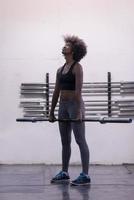 black woman lifting empty bar photo