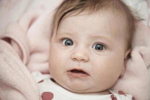 cute little baby playing with hands and smiling photo