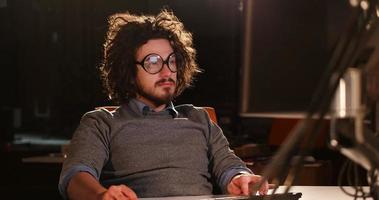 man working on computer in dark office photo