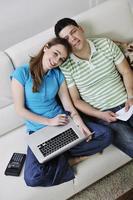 young couple working on laptop at home photo