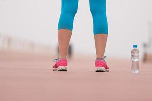 primer plano de los zapatos para correr y una botella de agua foto