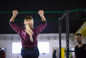 mujer haciendo pull ups en la barra horizontal foto