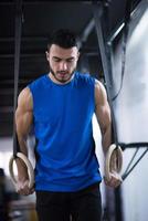 man working out pull ups with gymnastic rings photo