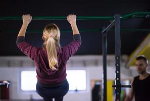 mujer haciendo pull ups en la barra horizontal foto