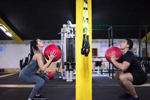 pareja de jóvenes atletas trabajando con pelota médica foto