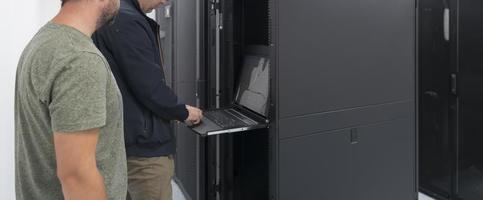 Technicians team updating hardware inspecting system performance in super computer server room or cryptocurrency mining farm. photo