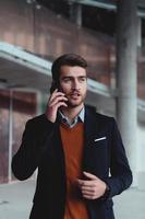 businessman architect using a smartphone while overseeing the construction site photo