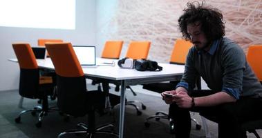 man using mobile phone in dark office photo