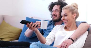 Young couple on the sofa watching television photo