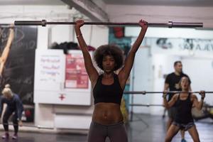 mujer negra levantando barra vacía foto