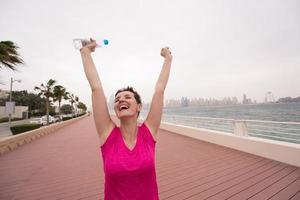 mujer joven celebrando una carrera de entrenamiento exitosa foto