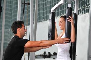 mujer en gimnasio con entrenador foto