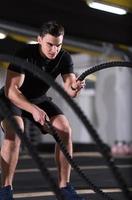 athlete man doing battle ropes cross fitness exercise photo
