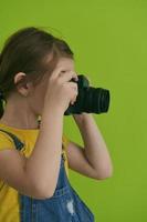 Cute little girl taking picture using  film photo camera