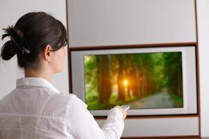 young woman watching tv at home photo