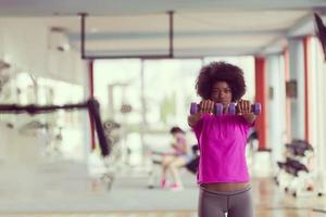 woman working out in a crossfit gym with dumbbells photo