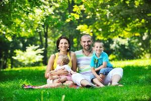 happy young couple with their children have fun at park photo