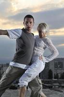 romantic urban couple dancing on top of the bulding photo